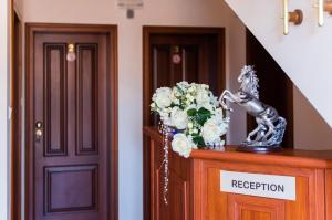 een vaas met bloemen bovenop een deur bij Family Hotel Elegance in Arbanasi