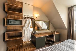 1 dormitorio con cama, escritorio y espejo en All Seasons Residence Hotel - Free parking, en Sofía
