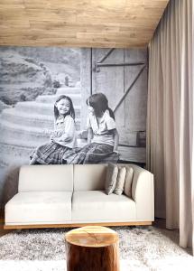 a living room with a couch and a painting on the wall at Fusion Suites Saigon in Ho Chi Minh City