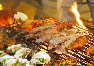 - un grill avec des fruits de mer et d'autres aliments dans l'établissement Nana Lee Homestay & Restaurant Quảng Bình, à Dong Hoi