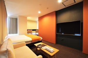 a hotel room with two beds and a flat screen tv at Randor Residence Tokyo Suites in Tokyo