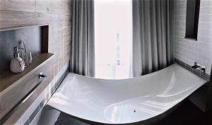 a bath room with a sink and a bath tub at Fusion Suites Saigon in Ho Chi Minh City