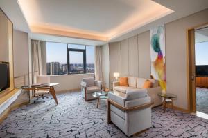 a living room with a couch and a television at Holiday Inn Tianjin Xiqing, an IHG Hotel in Tianjin