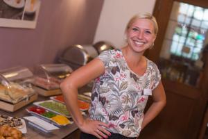 a woman standing in front of a counter with food at Hotel Krone in Hirschberg an der Bergstraße