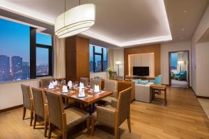 a dining room with a table and chairs and a living room at Holiday Inn Tianjin Xiqing, an IHG Hotel in Tianjin