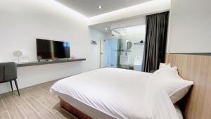 Habitación de hotel con cama y TV en Kimen Yuyu B&B, en Jinning