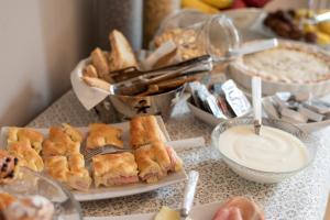 a table with sandwiches and dip and other food at IN LUCUS Guest House in Lucca