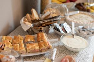 einen Tisch mit Sandwiches, Dip und anderen Speisen in der Unterkunft IN LUCUS Guest House in Lucca
