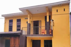 gelbes Apartmenthaus mit Balkon in der Unterkunft Airangga Home Stay Syariah Berastagi RedPartner in Berastagi