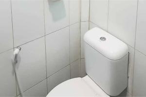 ein Badezimmer mit einem weißen WC in einer gefliesten Wand in der Unterkunft Airangga Home Stay Syariah Berastagi RedPartner in Berastagi