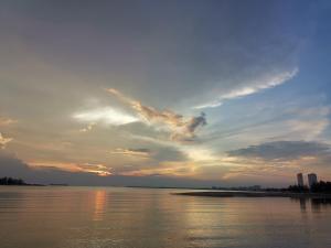 a sunset over a body of water with the sky at Syahmi Homestay Melaka in Melaka