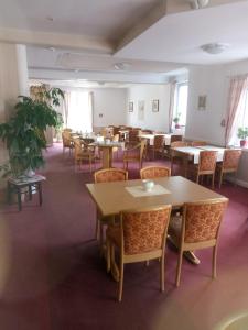 uma sala de jantar com mesas e cadeiras num quarto em Hotel Garni Bernhard am See em Walchsee
