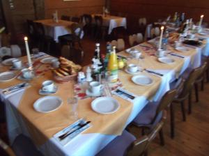 a long table with white plates and candles on it at Gasthof Stadtschänke in Großbottwar