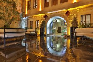 a lobby of a building with an archway and chairs at Aja Cappadocia Cave Hotel in Ürgüp