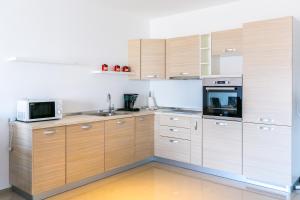 a kitchen with wooden cabinets and a microwave at Vizula Sunset D - Antonio & Ulla & Undine in Medulin +58 photos