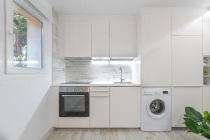 cocina blanca con fregadero y lavavajillas en Apartamento Playabella, en Estepona