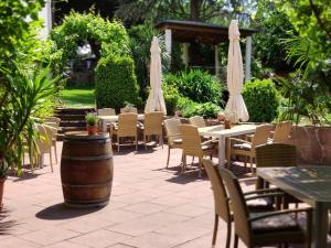an outdoor patio with tables and chairs and umbrellas at Winzergarten Hotel-Restaurant in Großkarlbach