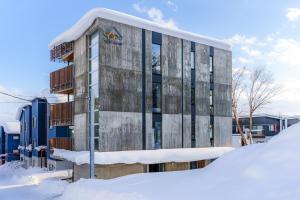 a building with snow in front of it at Yotei Dream One by H2 Life in Niseko