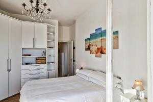 - une chambre blanche avec un lit et un lustre dans l'établissement Homey Seaview Apartment by Wonderful Italy, à Gênes