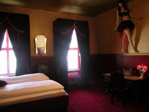 a bedroom with a bed and a woman jumping on the wall at Arte Luise Kunsthotel in Berlin