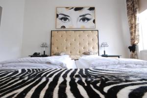 a bedroom with two beds with a zebra print headboard at Arte Luise Kunsthotel in Berlin