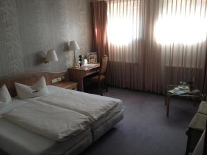 a hotel room with a bed and a desk at Gästehaus Stelle in Gammertingen
