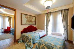 イスタンブールにあるロマンス イスタンブール ホテル ブティック クラスのベッド2台と鏡が備わるホテルルームです。