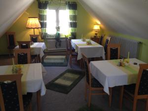 een restaurant met witte tafels en stoelen en een raam bij Gästehaus Stelle in Gammertingen