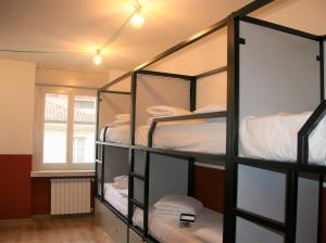 a room with four bunk beds with a window at Hotello Hostel in Trieste