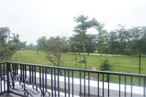 a balcony with a view of a field and trees at RedDoorz near Araya Family Club House in Malang