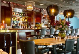 un restaurante con mesa de madera y sillas y un bar en Reenskaug Hotel, en Drøbak