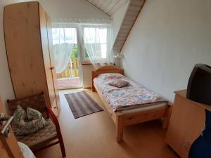 Habitación pequeña con cama y ventana en Ferienwohnungen Leffer en Großheirath