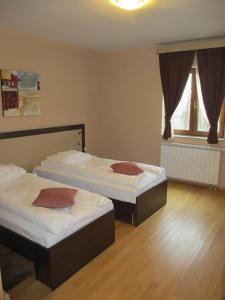 two beds sitting in a room with wooden floors at Apartments Manjan in Krasno Polje