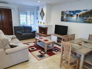 una sala de estar con un sofá y una mesa en Spacious Ground floor apartment with Garden & Communal Pool, en Los Dolses