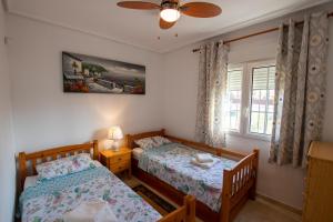 Un dormitorio con dos camas y una ventana. en Spacious Ground floor apartment with Garden & Communal Pool, en Los Dolses 44 fotos más