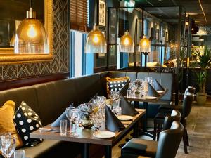 a row of tables in a restaurant with lights at Reenskaug Hotel in Drøbak