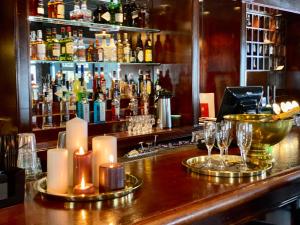 un bar con candele e bicchieri su un bancone di Reenskaug Hotel a Drøbak