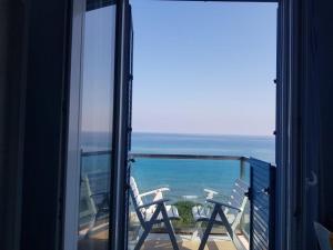 a balcony with a view of the ocean from a window at Hotel Tourist in Cefalù