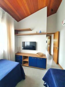 um quarto com uma cama e uma televisão num quarto em Villagio di Mare em Barra Grande