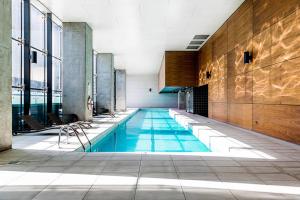 a swimming pool in a building with a large window at A Lovely Studio Next to Southern Cross in Melbourne