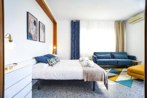 - une chambre avec un lit et un canapé bleu dans l'établissement Pool House Barcelona, à Barcelone