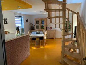 a kitchen and dining room with a table and a spiral staircase at Ferienwohnung am Eiskeller in Ankershagen