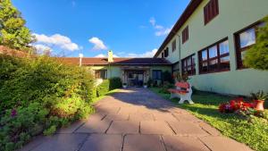 una casa con un passaggio pedonale in mattoni accanto a un edificio di Pousada Casa da Paz a Gramado