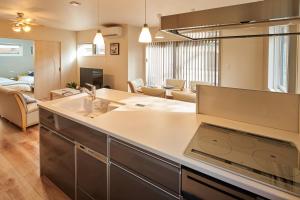 a kitchen with a sink and a living room at Compass Karuizawa in Karuizawa