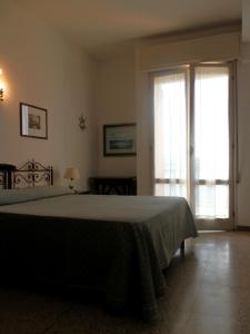 een slaapkamer met een bed en een groot raam bij Hotel Nautic B&B in Bellaria-Igea Marina