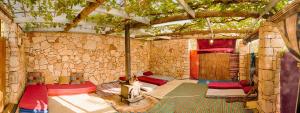 um quarto com várias camas num edifício de pedra em Back to Nature Camping & Huts em Mikhmannim