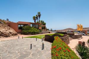 a house with a garden with flowers in front of it at GreenSide 38 by VillaGranCanaria in San Bartolomé