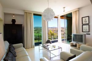 a living room with a couch and a television at GreenSide 38 by VillaGranCanaria in San Bartolomé de Tirajana