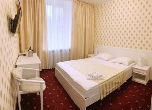 a bedroom with a bed and a chair and a window at Sergeev Hotel in Mykolaiv