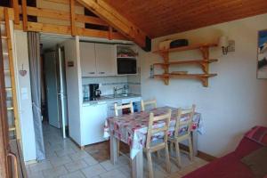 a kitchen with a table and chairs in a room at GREEN APPLE CARROZ Duplex WIFI Garage Balcon-Sud Vue Montagne in Les Carroz d'Araches